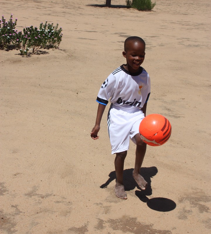 Afrikanischer Junge spielt Fußball