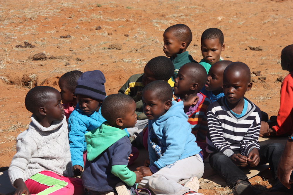 Afrikanische Kinder sitzen zusammen